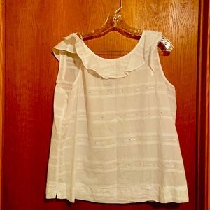 White sleeveless top with frilly color and small gold sequin detail.